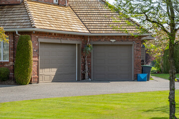 Garage door in luxury house with trees and nice landscape in Spring in Vancouver, Canada, North...