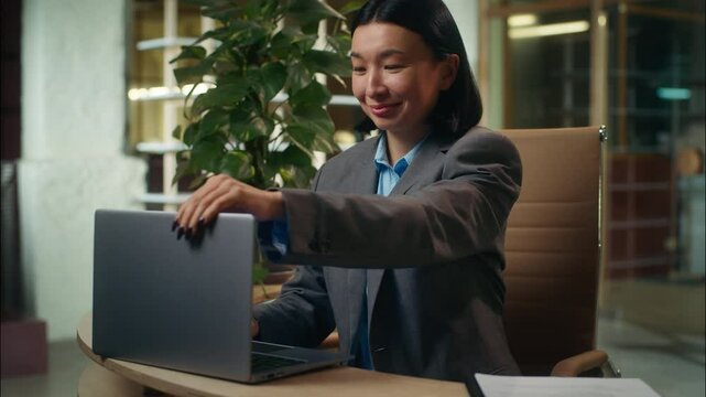 Happy Asian Korean Chinese Japanese woman finished laptop online work close computer businesswoman end job done stretching arms employee relaxing project accomplishment business female girl in office
