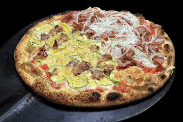Brazilian pizza with half with meat, cheese and onions and the other half with slices of zucchini, cheese and bacon