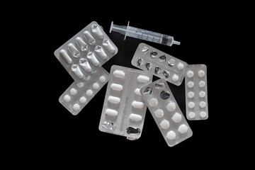 A close-up shot of different drugs and medicine on a black background