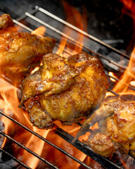 Three pieces of chicken are on a grill, with one piece being the largest