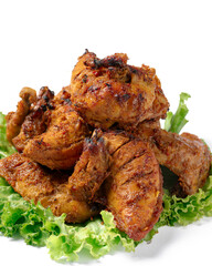A plate of grilled chicken with green lettuce on top