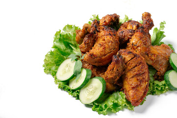 A plate of chicken with cucumber and lettuce on top