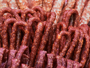 Savory delicacies of dried meat twisted into delightful shapes for sale at a bustling market during a sunny afternoon