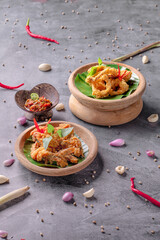 Two bowls of food with a leaf on top