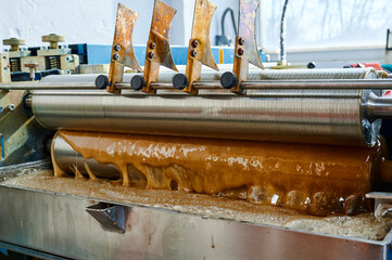 Efficient hot glue application process with specialized glue-spreading machine in action at a...
