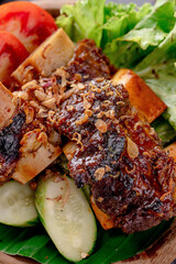 A plate of meat and vegetables with a lot of sauce