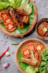 Two plates of food with meat and vegetables, including tomatoes and cucumbers