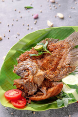A plate of fish with a green leaf on top