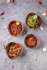 Four bowls of food are arranged on a gray surface