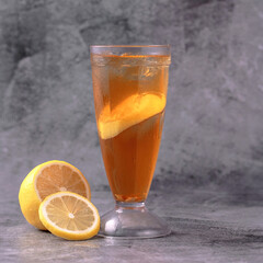 A glass of lemonade with a slice of lemon on the side