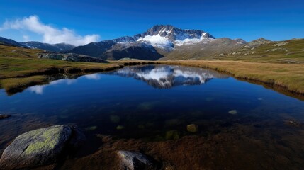 Fototapeta premium Serene mountain lake mirroring a snow-capped peak