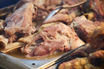 Slow-cooked meat served at a busy food stall during evening hours