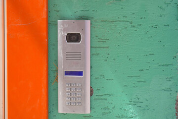 Modern intercom system mounted on a colorful wall in a urban setting