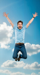 Joyful man jumping against a blue sky with clouds  