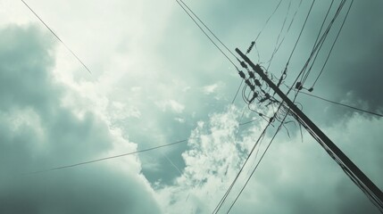 Fototapeta premium Power lines extending into a cloudy sky