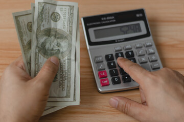 A man meticulously counts dollar bills, reflecting the concept of currency management in investments, salaries, shopping, and business transactions.