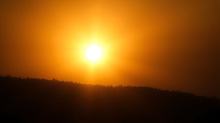 Fototapeta premium Golden Sunset over Silhouetted Hills