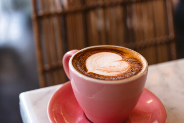 Cappuccino with delicious milk foam in a pink mug close-up. Delicious coffee for breakfast
