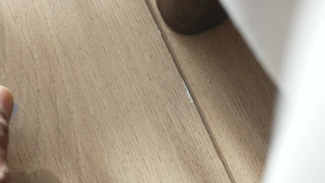 SIM card found on wooden floor near a furniture leg, lost sim card concept 