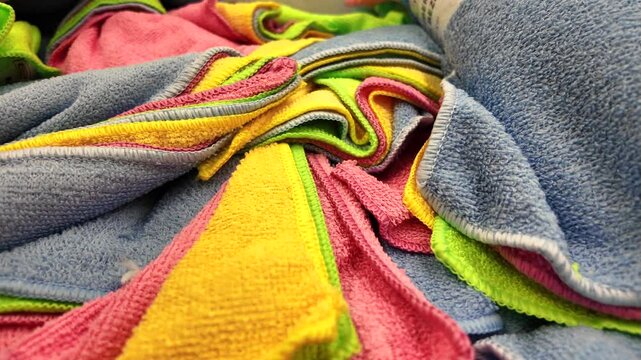 Colorful towels piled up in a laundry room for cleaning tasks