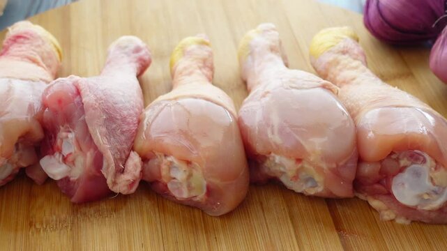 Cooking chicken drumsticks with fresh purple onions at home