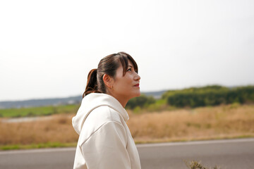 野原で空を見上げる女性