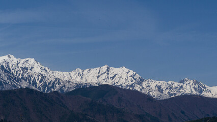 春の北アルプスと市街地の街並み　長野県大町市