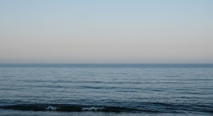 Fototapeta premium Serene Seascape Calm Ocean Waves at Dawn or Dusk