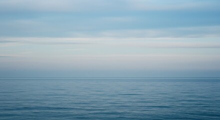 Obraz premium Serene Seascape Calm Ocean Under a Pale Sky