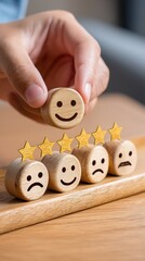 A hand places a happy face on top of a stack of customer feedback symbols, suggesting positive reviews