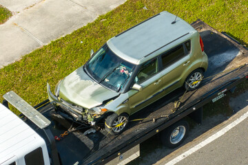 Car crash with tow truck hauling damaged car and first responders helping at accident site on...