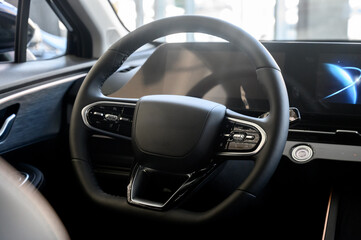 Obraz premium Modern car interior with black steering wheel, digital instrument panel