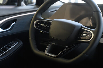 Fototapeta premium A close-up of a modern car's steering wheel with control buttons