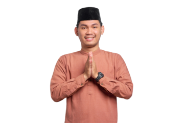 Smiling young Asian Muslim man gesturing Eid Mubarak greeting isolated on transparent background