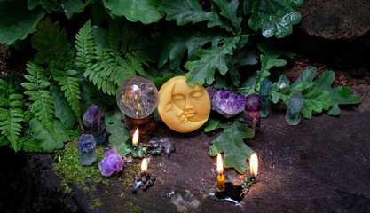 amulet of moon, burning candles, minerals, crystal quartz ball in forest, natural background....