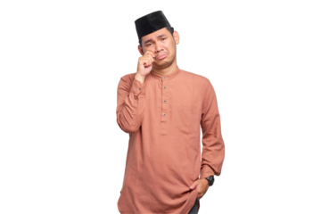 Young Asian Muslim man rubs tears wants to cry feeling depressed has a problem isolated on transparent background