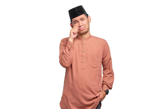 Young Asian Muslim man rubs tears wants to cry feeling depressed has a problem isolated on transparent background