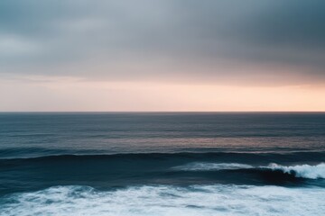 Obraz premium 波がゆったりと打ち寄せる海と夕方の静けさに包まれる風景。