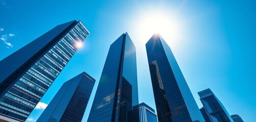 Sleek glass skyscrapers pierce a vibrant blue sky, reflecting sunlight in a modern cityscape, sunlight, clear