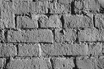Fragment of brickwork, close-up. Brick wall, close-up. Potholes and defects in a brick wall, flat layout. Cracks and defects in bricks on a wall, color fantasy.