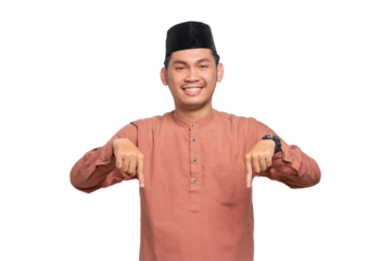 Portrait of Asian Muslim man smiling pointing fingers down, inviting customers to special event isolated on transparent background