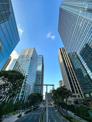 都会の高層マンションと青空と白い雲と緑の植物、昼