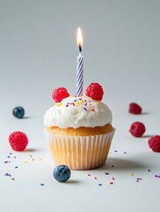 Delicious cupcake with a candle and fresh berries on a bright background perfect for celebration and birthday themed designs captures a sweet treat