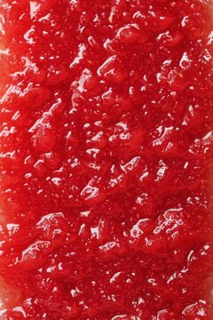 Vibrant close up of homemade strawberry jam showcasing its rich texture and glistening surface inviting a taste of summer sweetness perfect for culinary projects