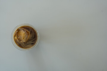 Overhead view of an iced Americano or iced black coffee with square ice cubes in plastic cup, copy space