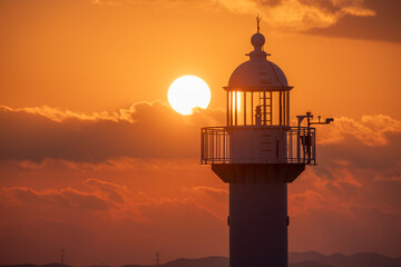 This is a picture of a lighthouse by the sea with a sunset view.
