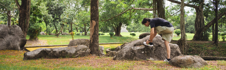 Naklejka premium wellness concept with asian man exercise with tree in park on summer season