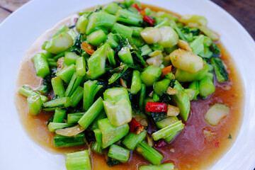 Fresh stir fried kale in oyster sauce in white dish is tradition food of Thailand