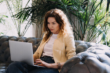 Numerologist working on a laptop in a serene modern lounge space. Modern numerology, digital divination, intuitive analytics, spiritual self-guidance...